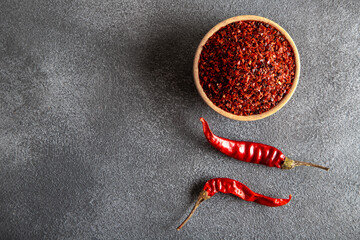 Red pepper flakes.Red chili peppers in wooden bowl on gray background.Dried chili peppers