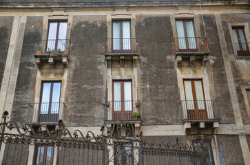 Characteristic Italian facades of tenement houses with balconies in Catania
