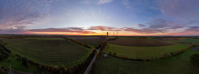 Obraz premium Aerial Panoramic Landscape at Sunset with Wind Turbines