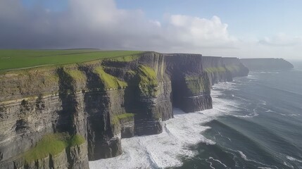 Dramatic aerial view of majestic cliffs meeting a turbulent ocean.