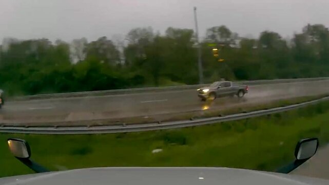U.S. truck jackknifed during a heavy rainstorm, showcasing the dangers of wet roads and poor visibility