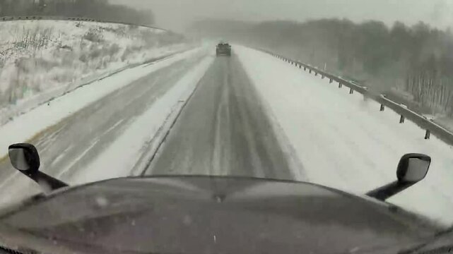 Terrifying Jackknife Truck Crash on Black Ice During Snowy Winter Weather. Captured on snowy highway, truck jackknifing on black ice, highlighting the dangers of winter driving in treacherous weather