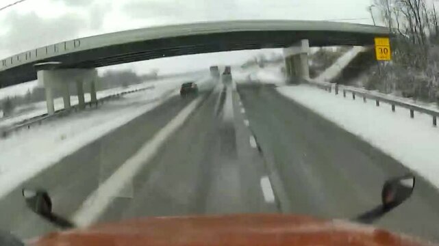 Terrifying Jackknife Truck Crash on Black Ice During Snowy Winter Weather. Captured on snowy highway, truck jackknifing on black ice, highlighting the dangers of winter driving in treacherous weather