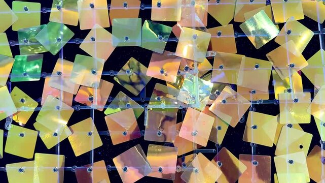 4k footage, close up of glimmering mirror sequin tile foil paper forming tinsels. Reflective glossy foil paper cut in square, christmas decoration. Reflection effects, various colors.