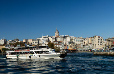 Fototapeta premium A picturesque view of the Bosphorus with the white ferry gliding across the calm waters with the iconic Galata Tower visible in the background a symbol of Istanbul's rich history and cultural heritage