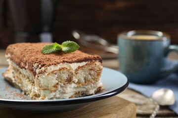 Piece of tasty tiramisu on wooden table, closeup