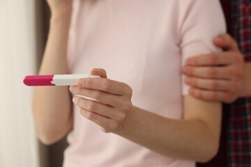 Obraz premium Woman with negative pregnancy test indoors, closeup. Man supporting his wife at home