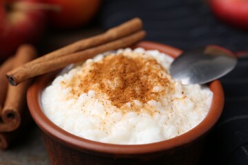 Delicious rice pudding with cinnamon on table, closeup