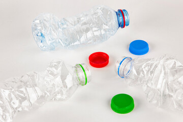 Plastic water bottle isolated on white background. Used twist water plastic bottles with colored caps.