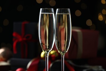 Delicious champagne in glasses against blurred lights, closeup. Christmas celebration