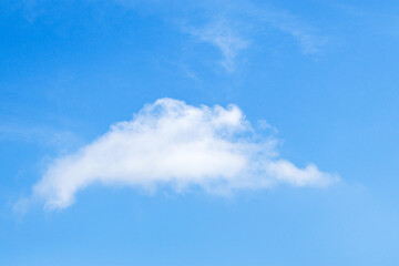 Fluffy white cloud drifting in a clear blue sky on a sunny day