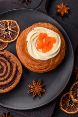 Sweet dessert danish covered with white cream and citrus, with cream filling