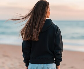 Young woman enjoying a sunset walk along the beach shore