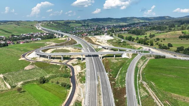 Last fragment of Zakopianka highway, Poland, between Rdzawka nad Nowy Targ with junction with traffic circle, ramps and high viaduct over Klikuszowa village, just opened in September 2024. Aerial view