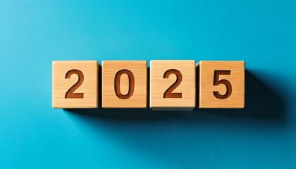 Wooden blocks arranged to form '2025' against a vibrant blue backdrop, in a 3D style