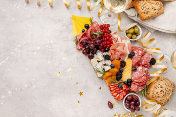 Food antipasto prosciutto ham, salami, olives and grissini bread sticks. cheese on a board parmesan, pecorino, gorgonzola. Charcuterie board. Two glasses of white wine or prosecco	