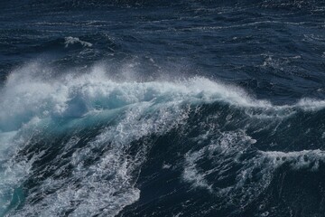 Majestic ocean waves crashing with white foam against deep blue sea, creating dynamic and powerful...