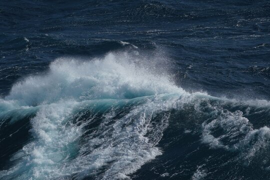 Majestic ocean waves crashing with white foam against deep blue sea, creating dynamic and powerful scene. energy of water is captivating and evokes sense of tranquility
