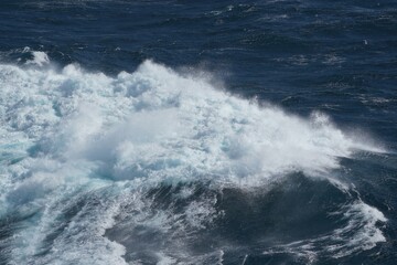 Powerful ocean waves crashing against each other create stunning display of nature force and beauty. deep blue water contrasts with white foam
