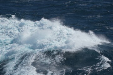 Majestic ocean waves crashing against each other create stunning display of nature power and beauty. vibrant blue water contrasts with white foam, evoking sense of tranquility and awe
