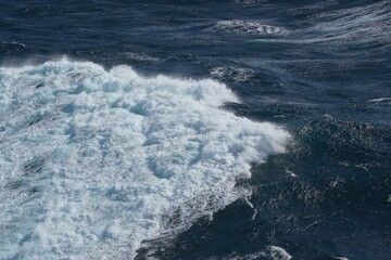image captures dynamic movement of ocean waves, showcasing vibrant blue water and frothy white surf. scene evokes sense of tranquility and power of nature