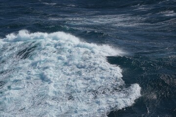 Majestic ocean waves crashing against each other create stunning seascape. deep blue water contrasts beautifully with white foam, evoking sense of tranquility and power