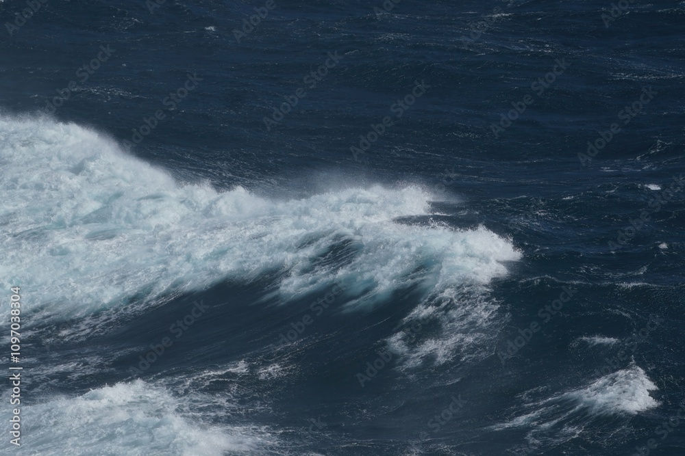 Wall mural waves crashing on dark ocean surface, creating dynamic and powerful scene. contrast of white foam ag