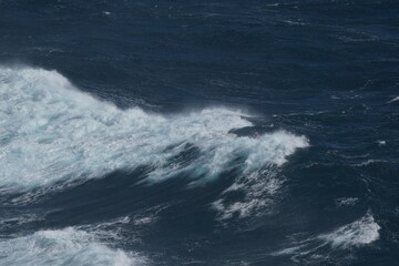 Majestic ocean waves crashing against each other, creating dynamic seascape. deep blue water...