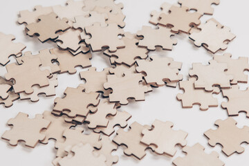 Wood jigsaw piece on wooden background, A piece of white jigsaw puzzle, wooden puzzles scattered on a white background