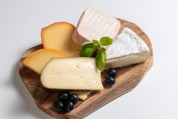 types of cheese on wooden board,cheeses maturing on wood on a white background, different types of cheeses, cheese cutting desk, Tasty maturing, blue cheeses