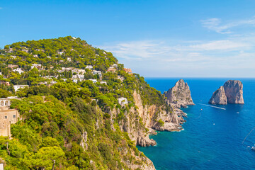 The photo of a breathtaking view of the town of Capri, highlighting the Gardens of Augustus with their vibrant flowers and greenery, set against the backdrop of the coastline. Italy