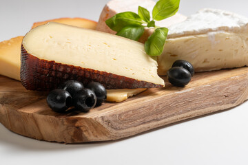 cheese and olives, aged cheeses on wood over white background, Different types of cheeses, Cheese slices desk, 
Tasty ripening, mold cheeses