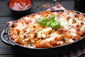Delicious al forno pasta in baking dish on wooden table, closeup
