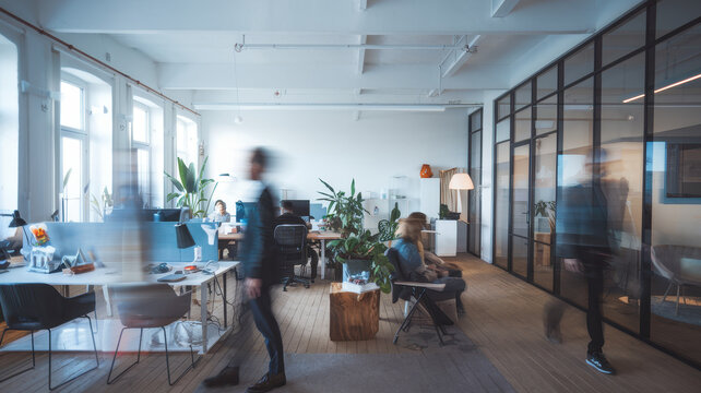 A modern office space bustling with activity, featuring diverse individuals engaged in collaborative work and creative brainstorming.