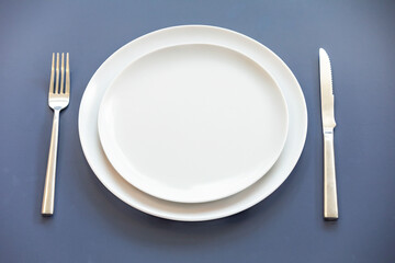 Empty plate top view with metal cutlery next to it