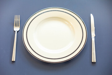 Empty plate top view with metal cutlery next to it