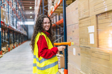 Young Female warehouse worker scanning packages with barcode scanner