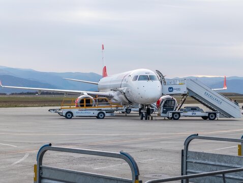 3 november 2024, Sibiu, Romania. Austrian airlines aircraft standing on tarmac in Sibiu international airport. Stairs next to the airplane. Baggage handling conveyor belt standing next to the plane.