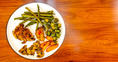 Real, strong, healthy, nutritious food, grilled chicken, pimenta biquinho, asparagus, mushrooms, Brussels sprouts and carrots.