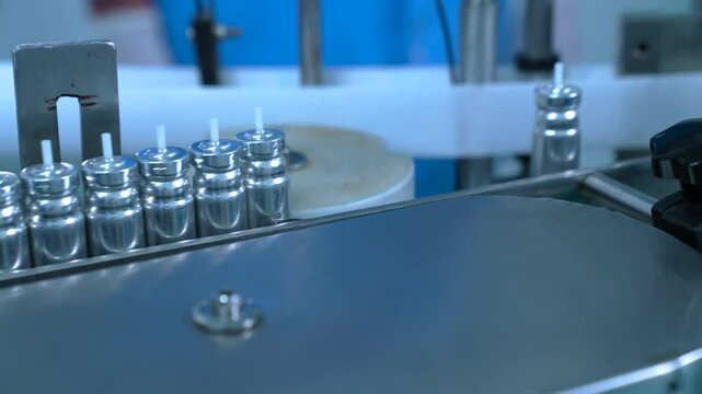 asthma inhaler canisters containers in production line. inhaler manufacturing. canister making process in a factory. asthma medicine in metal bottles on a conveyor belt. Pharmaceutical product	