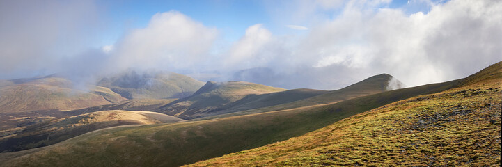 Blencathra and Lonscale Fell wreathed in clouds, seen from the summit ridge of Skiddaw, Keswick, Lake District, UK