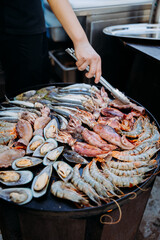 Chef grilling fresh seafood on a hot plate, showcasing shrimp, mussels, and squid for gourmet dining
