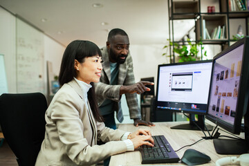 Diverse business people working together on office computer