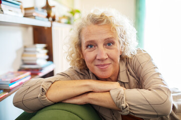 Portrait of a confident mature woman sitting at home looking thoughtful