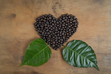 Kaffeeliebe: Herz aus Kaffeebohnen und frischen Bl&auml;ttern

