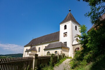 Fototapeta premium Ancient clock tower of Pfarre Schonbuhel church in Austria