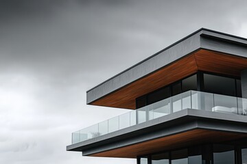Fototapeta premium Elevation of a contemporary home with cantilevered floors and extensive use of glass, under an overcast sky.