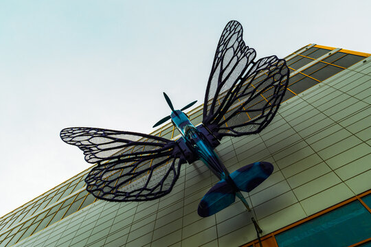 Prague, Czechia - August 9 2024: Creative Art Installation of a Winged Aircraft Sculpture on a Modern Building Facade, M&aacute;j Shopping Center