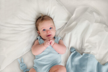 Little newborn baby boy, sleeping with teddy bear at home in bed