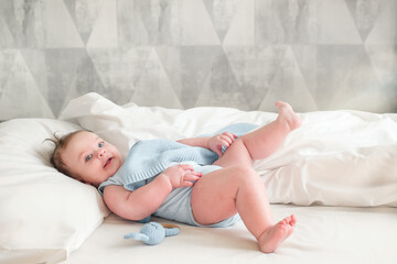 Little newborn baby boy, sleeping with teddy bear at home in bed